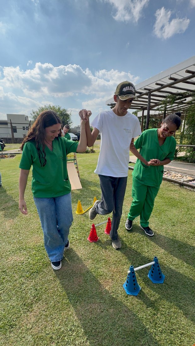 Equipe da Hippus Aldeia acompanhando um adolescente em circuito motor no gramado