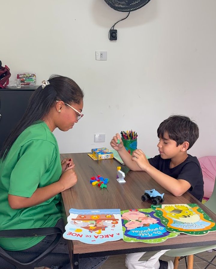 Profissional da Hippus Aldeia em atividade de mesa com uma criança