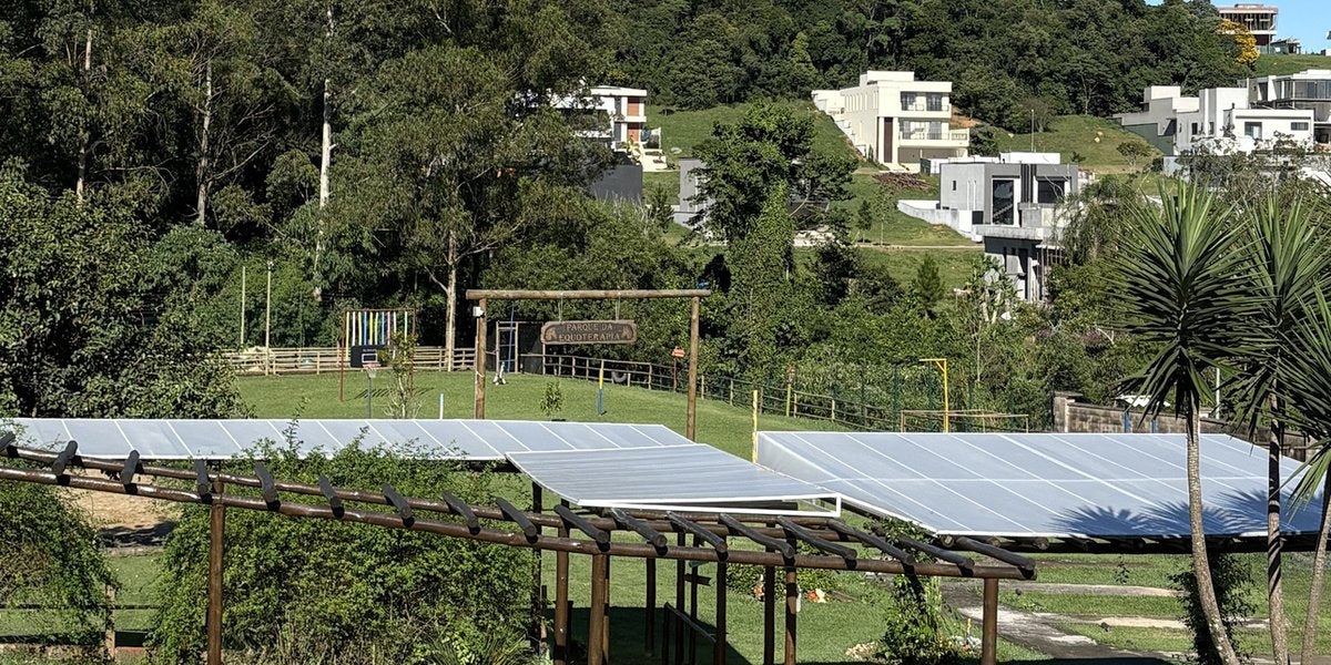 Área externa da Hippus Aldeia com pergolado de madeira em meio à mata