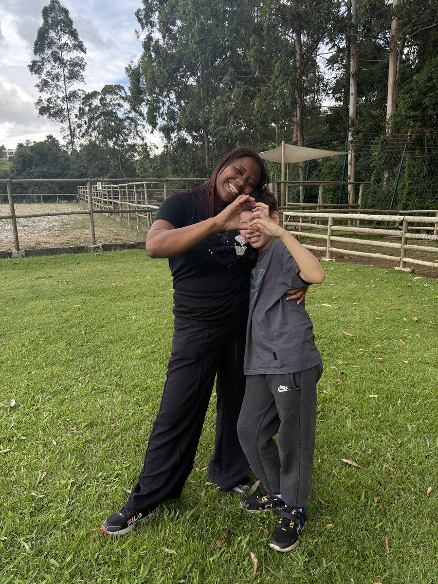 Acompanhamento terapêutico na Hippus Aldeia: profissional e criança ao ar livre formando um coração com as mãos